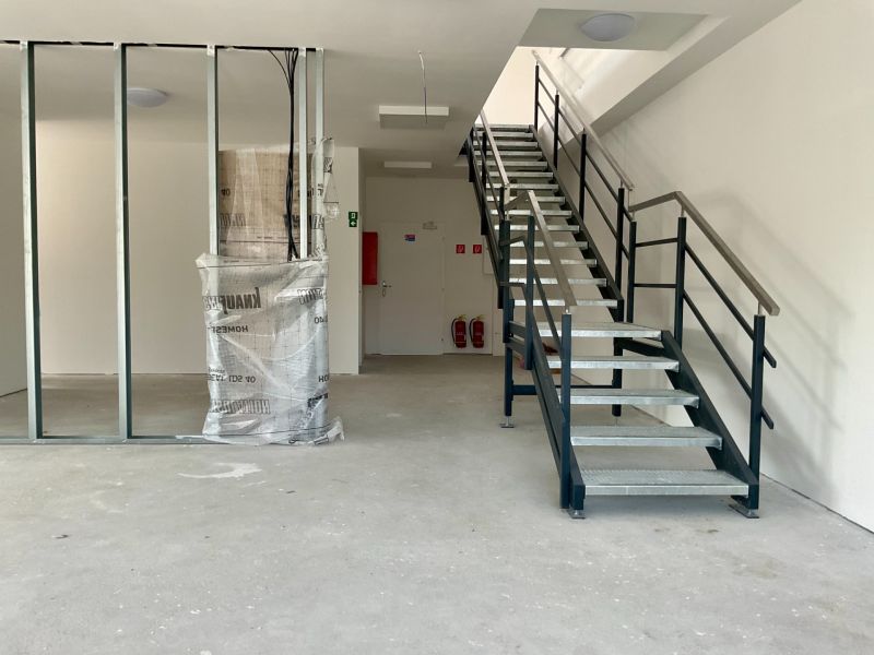 Innenraum mit Treppe in Lagern und Hallen mit Metallgeländer und Tragbalken.