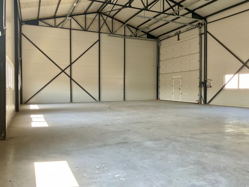 Ein Raum in der Halle mit einem Eingangstor und erleuchteten Wänden, geeignet für Lager und Hallen.