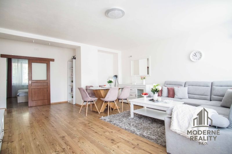 Wohnzimmer in einer 2-Zimmer-Wohnung mit Holzboden und bequemer Couch.