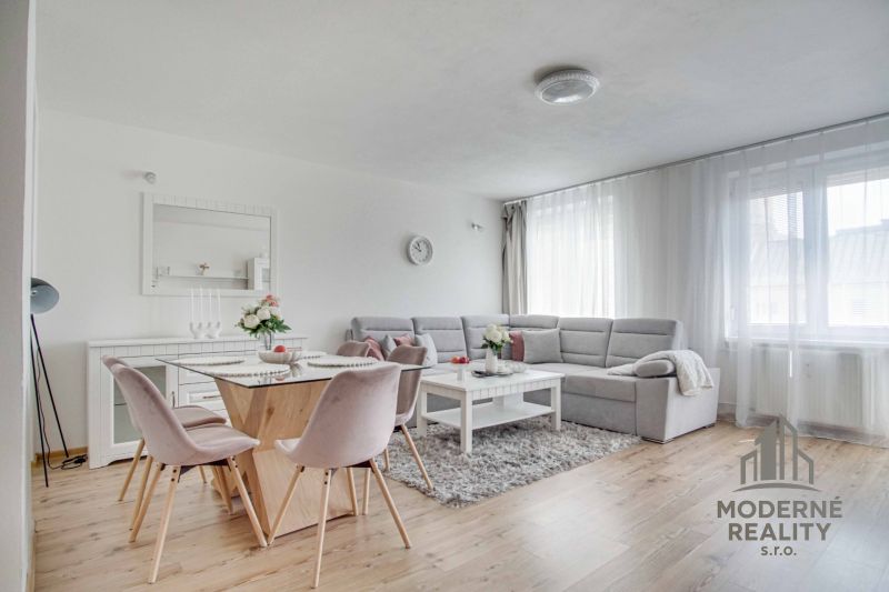 Helles Wohnzimmer mit Sofa, Esstisch und Holzboden.