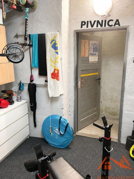 Fitness-Ecke mit Krafttrainingsgerät und Aufbewahrungselementen, geeignet für eine 3-Zimmer-Wohnung.
