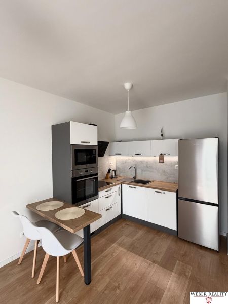 Küche in einer 2-Zimmer-Wohnung mit Eckküche und Boden in Holzoptik.