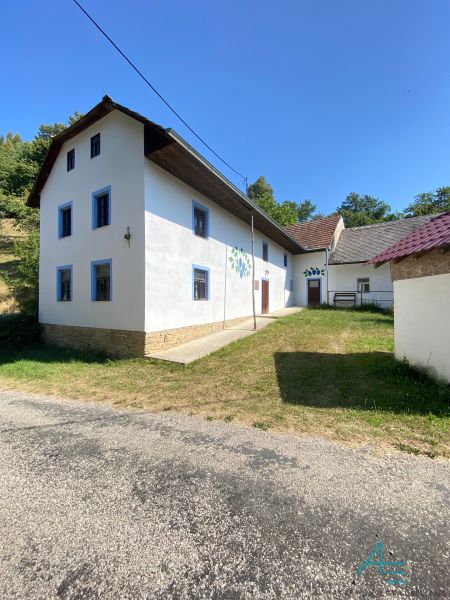 Ein Einfamilienhaus in Brestovec in der Straße Brestovec mit weißer Fassade und blauen Fenstern.