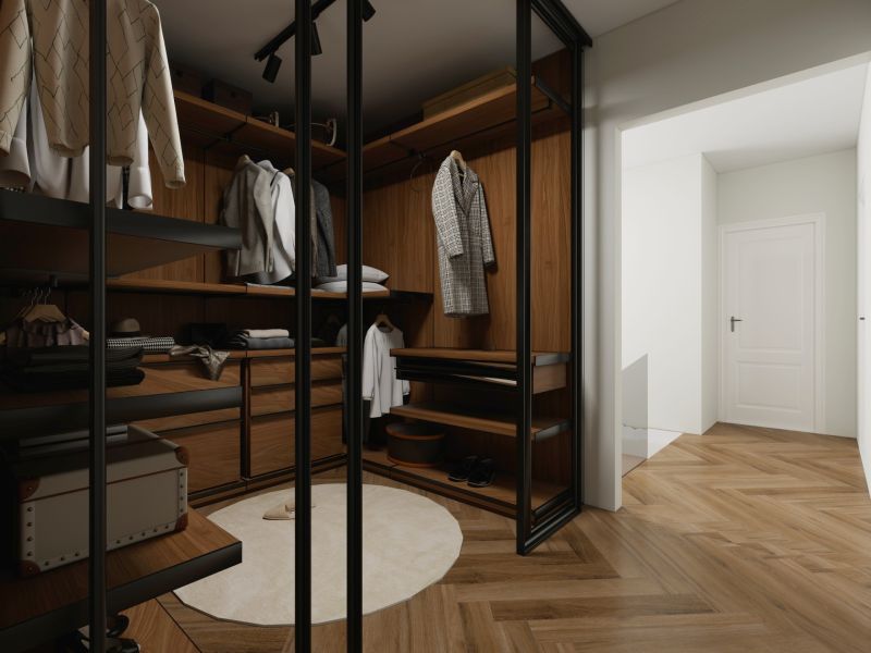 Ein Kleiderschrank im Einfamilienhaus mit Regalen, Spiegeltüren und einem Boden in Holzoptik.