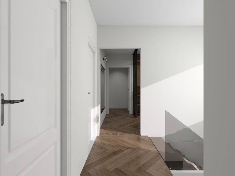 Der Flur in einem Einfamilienhaus mit Holzboden und weißen Wänden.