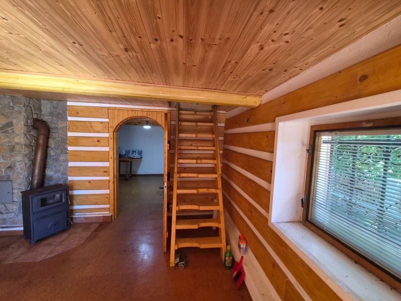Holztreppe, Herd und Steinverkleidung in einem Einfamilienhaus mit Holzbodenoptik.