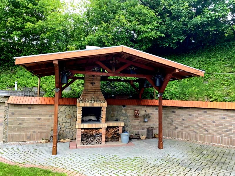 Ein Pavillon mit gemauertem Kamin im Garten eines Einfamilienhauses in Mikušovce.