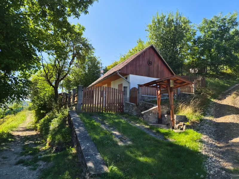 Ein Familienhaus in Mikušovce, umgeben von Grünflächen, mit einem Weg, der zu einem hölzernen Tor führt.