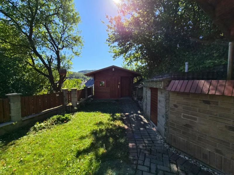 Garten bei einem Einfamilienhaus in Mikušovce, Sitzecke in der Natur, sonniger Tag, Steinweg.