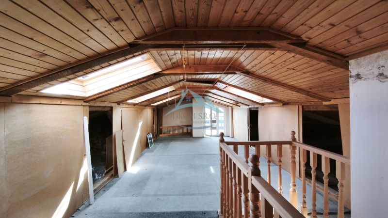 Das Dachgeschoss eines Einfamilienhauses mit Holzverkleidung und Dachfenstern.