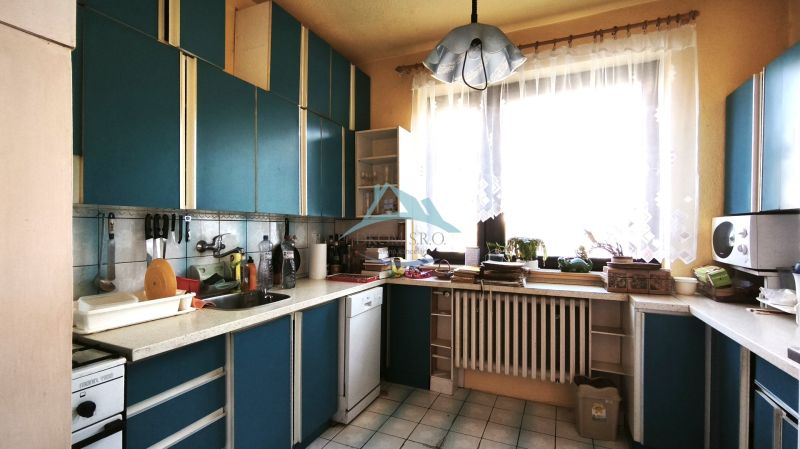 Eine Küche in einem Einfamilienhaus mit blauer Küchenzeile und großem Fenster, die Atmosphäre eines Zuhauses.