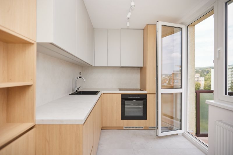 Küche in einer 3-Zimmer-Wohnung mit hellen Schränken und großem Fenster.
