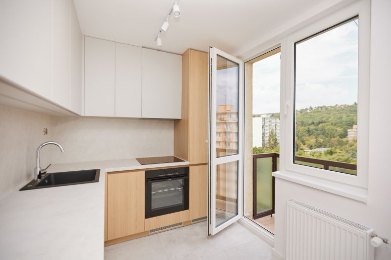 Küche in einer 3-Zimmer-Wohnung mit Blick vom Balkon und einem Boden mit Holzdekor.