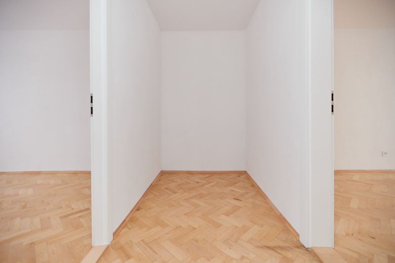 Weiße Wand und Boden mit Holzdekor in einer 3-Zimmer-Wohnung.
