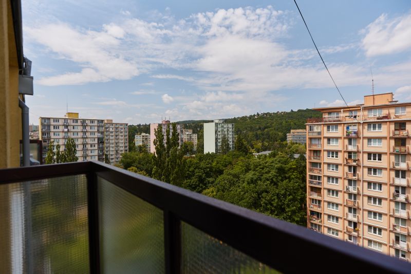 Blick vom Balkon mit Plattenbauten und Bäumen auf der Božena Němcová-Straße in Košice.