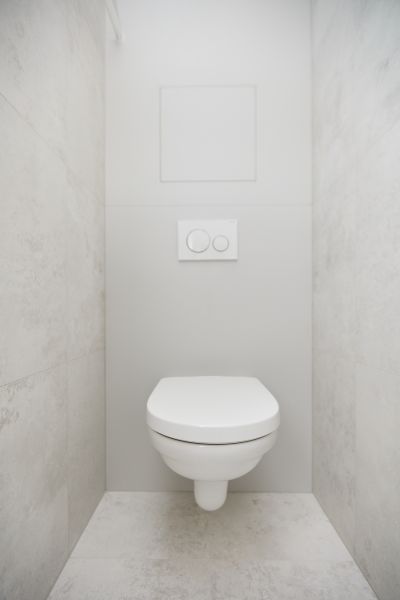 Minimalistisches WC in einer 3-Zimmer-Wohnung mit hellen Fliesen an den Wänden.