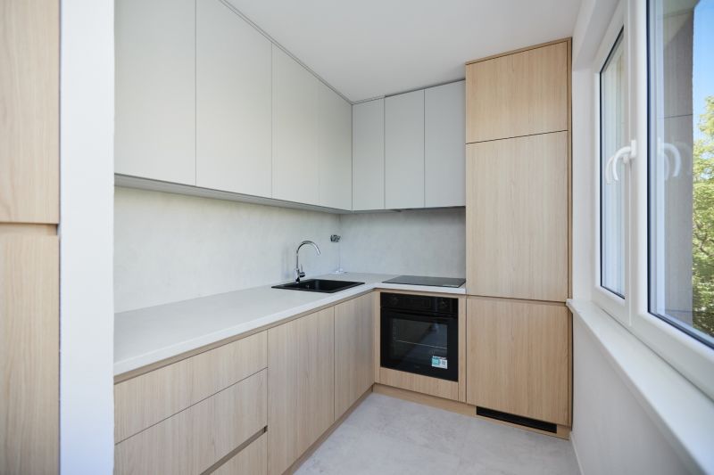 Eine Küchenzeile in einer 3-Zimmer-Wohnung mit Holzelementen und hellen Schränken.