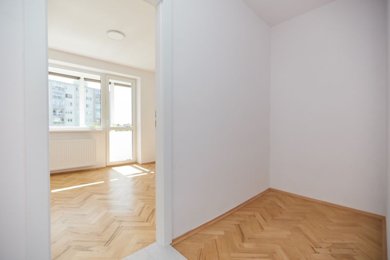Helles Zimmer in einer 3-Zimmer-Wohnung mit Holzboden und großem Fenster.