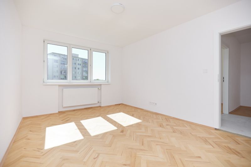 Helles Zimmer mit Holzboden in einer 3-Zimmer-Wohnung.