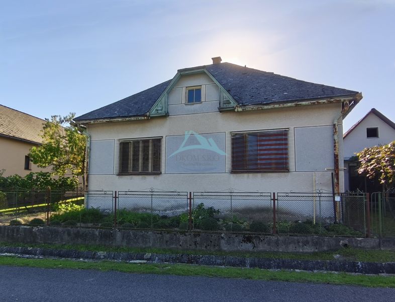 Ein Einfamilienhaus in der Komenského-Straße in Čebovce mit einer leicht vernachlässigten Fassade und einem Garten.