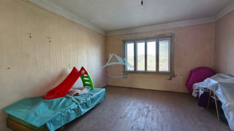 Ein Zimmer mit einem Holzboden und Spielzeug in einem Einfamilienhaus.
