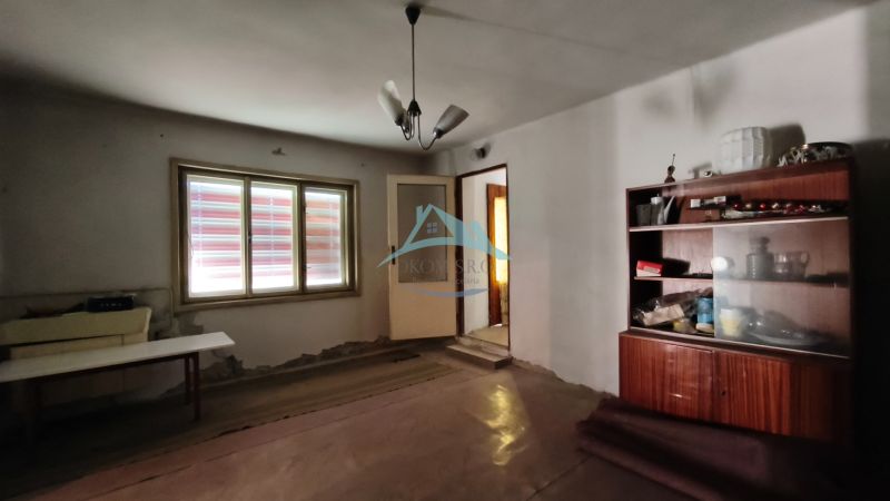 Ein Zimmer in einem Einfamilienhaus mit einfacher Einrichtung und einer Lampe an der Decke.