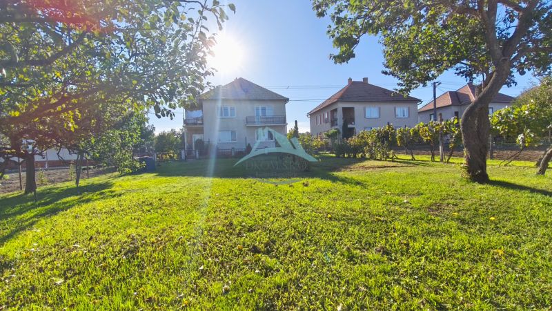 Der Garten des Einfamilienhauses in Čebovce, umgeben von Bäumen und Nachbarhäusern.