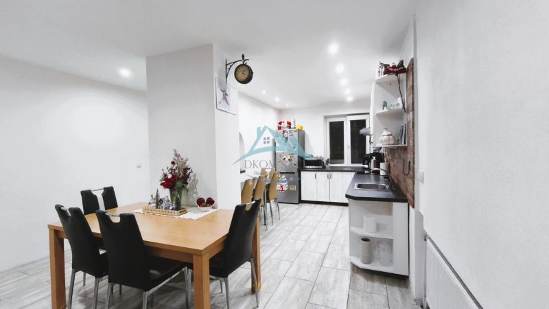 Küche in einem Einfamilienhaus mit Esstisch, schwarzen Stühlen und hellem Boden.