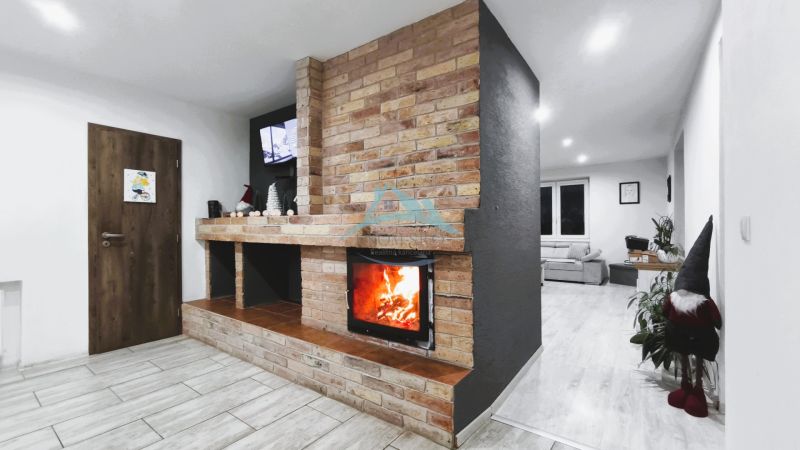 Ein Einfamilienhaus mit Kamin und Ziegelwand, Boden mit Holzdekor.