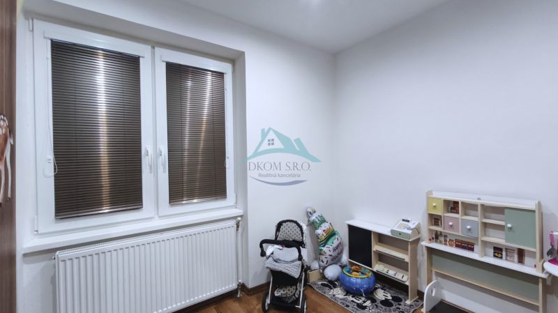 Kinderzimmer in einem Einfamilienhaus mit Spielzeug, Kinderwagen und Holzboden.