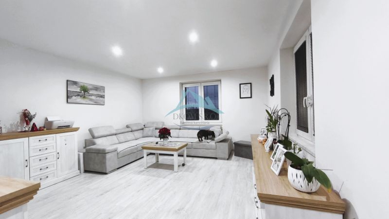 Wohnzimmer in einem Einfamilienhaus mit Sofa, Dekorationen und Holzboden.