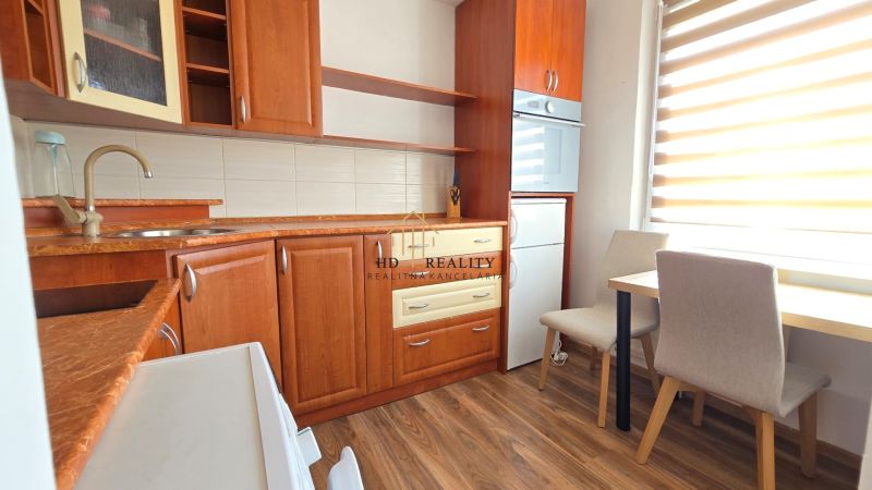Eine Küche mit Holzboden, Esstisch und Holzküchenzeile in einer Einzimmerwohnung.