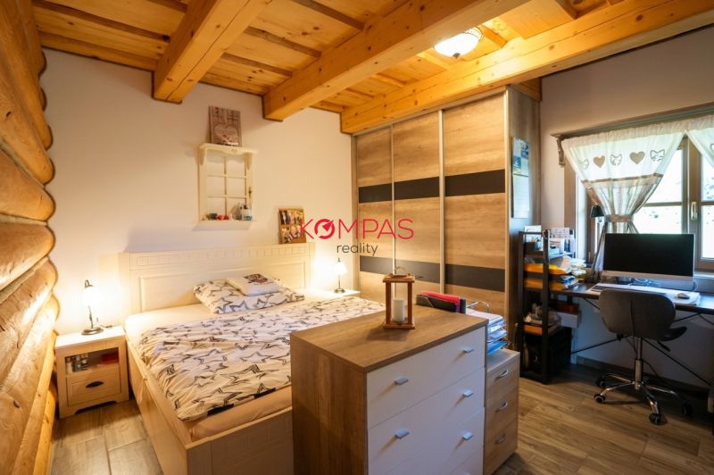 Ein Zimmer in einem Einfamilienhaus mit einem Bett, einem Schrank und einem Schreibtisch mit Computer.