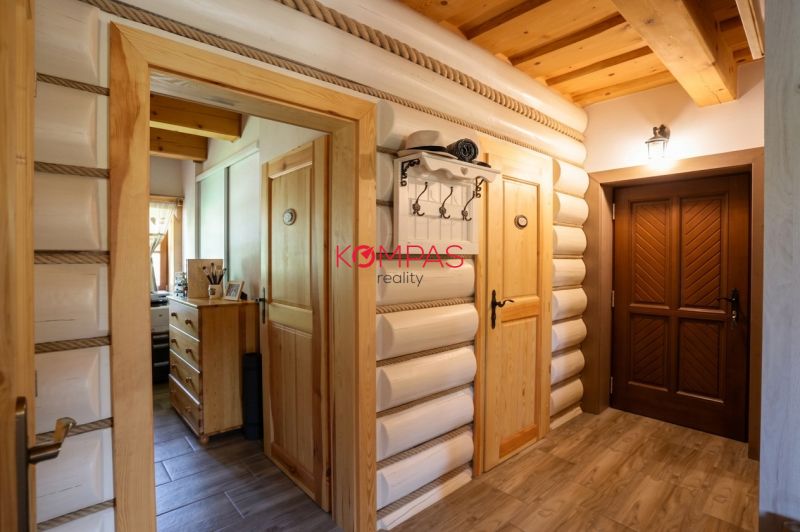 Innenraum eines Einfamilienhauses mit Holzwänden, einem Boden mit Holzdekor und Holztüren.