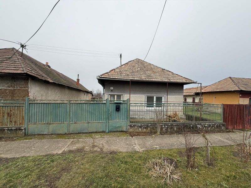 Ein Einfamilienhaus in Sikenica mit einem Blechzaun und einem Schrägdach.
