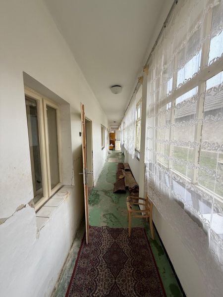 Ein heller Flur in einem Einfamilienhaus mit Teppich und Vorhängen.