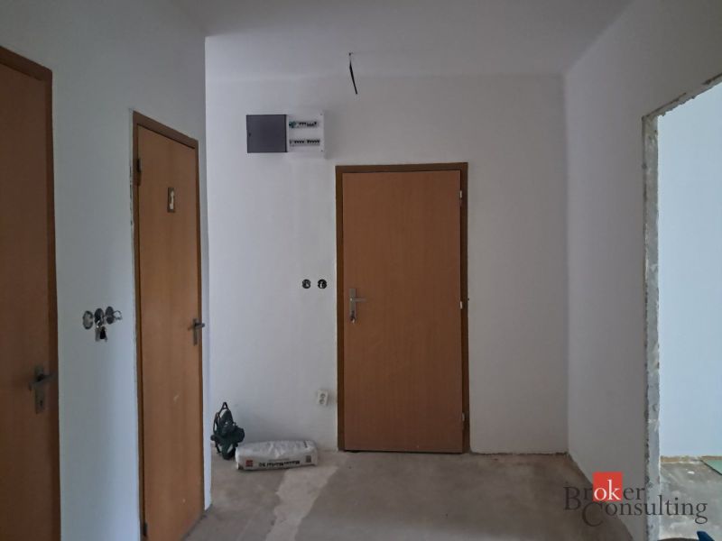 In einer 4-Zimmer-Wohnung sind Wände mit Türen und ein Verteilerkasten zu sehen.