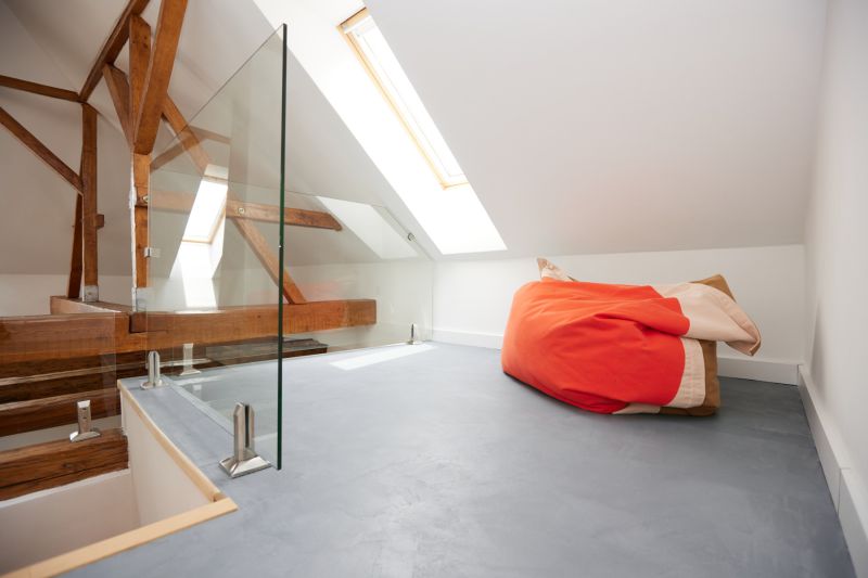 Dachbodenraum mit Glasgeländer und buntem Sitzsack in einer 3-Zimmer-Wohnung.