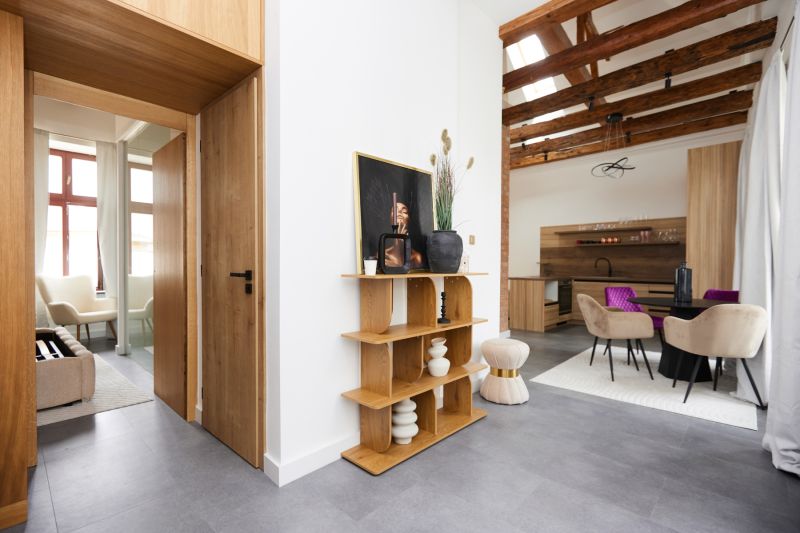 Innenraum einer 3-Zimmer-Wohnung mit Regal, eleganten Stühlen und Holzboden.