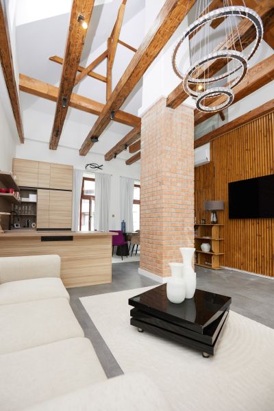 Wohnzimmer in einer 3-Zimmer-Wohnung mit sichtbaren Balken und einer Ziegelsteinsäule.