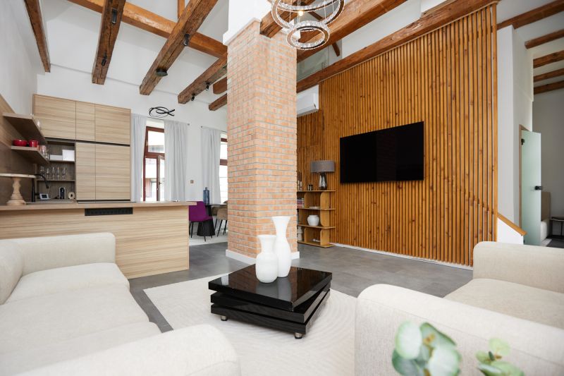 Wohnzimmer mit Ziegelwand, Holzboden und bequemen Sesseln in einer 3-Zimmer-Wohnung.
