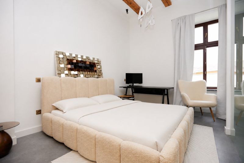 Helles Schlafzimmer mit bequemem Bett, Schreibtisch und Sessel in einer 3-Zimmer-Wohnung.