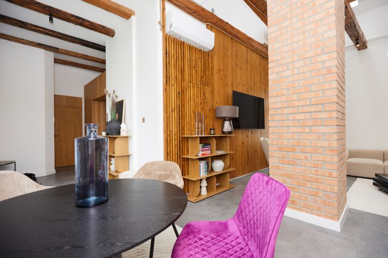 Innenraum einer 3-Zimmer-Wohnung mit Ziegelwand, Holzboden und bunten Möbeln.