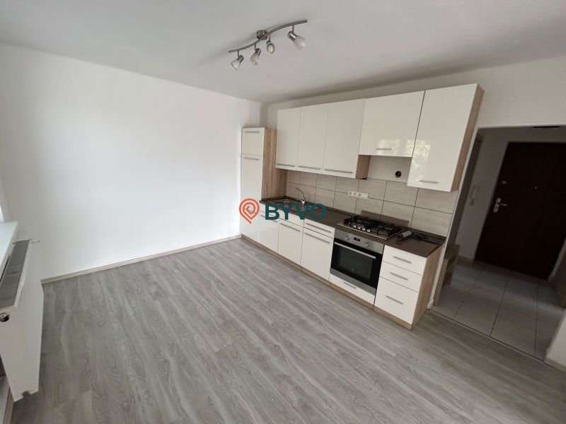 Küche in einer 3-Zimmer-Wohnung mit eingebauten Geräten, Boden mit Holzdekor.