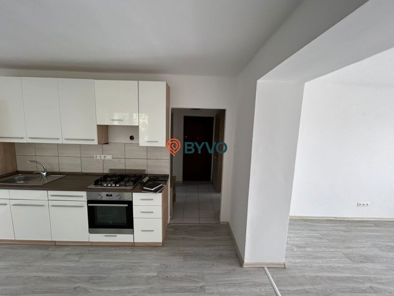 Küchenzeile mit Holzdekor in einer 3-Zimmer-Wohnung, Raum mit weißen Wänden.