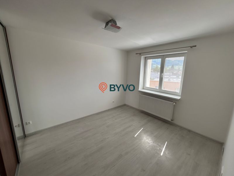 Ein leerer Raum mit Holzboden und weißen Wänden in einer 3-Zimmer-Wohnung.