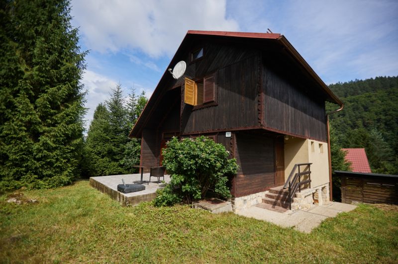 Das Haus auf Rovnom 61 in Jaklovce, umgeben von Bäumen, mit einer Außenterrasse.