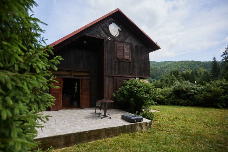 Das Haus auf Rovnom 61 in Jaklovce mit einer Holzfassade und einer Terrasse, umgeben von Grün.