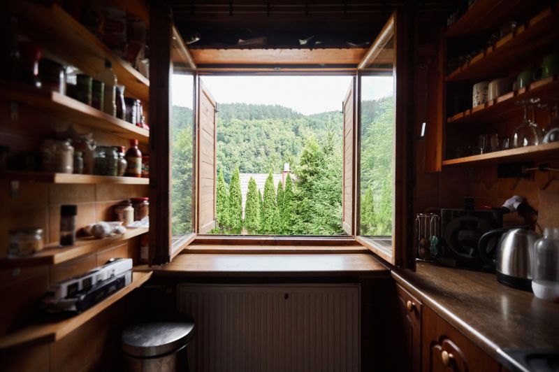 Küche in der Hütte mit Blick auf das Grün durch das offene Fenster.