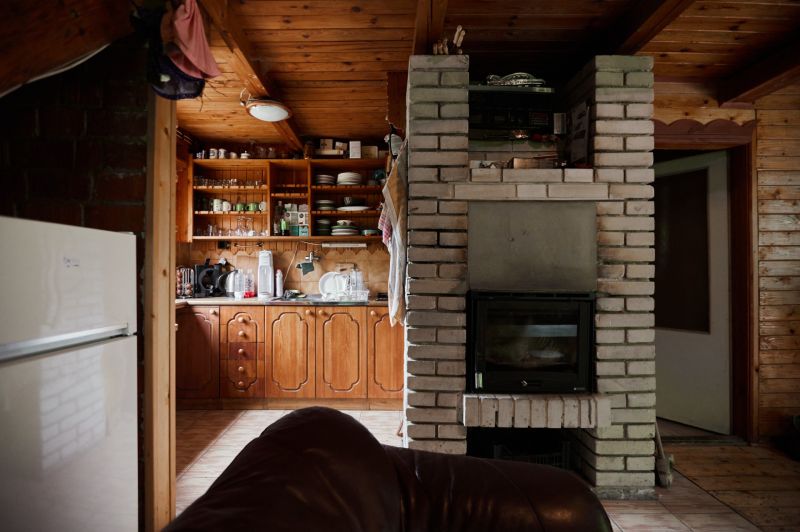 Das Innere der Hütte mit gemauertem Kamin, mit Holz verkleideten Schränken und Kochnische.